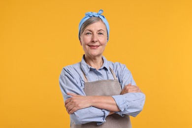 Photo of Portrait of happy housewife on orange background