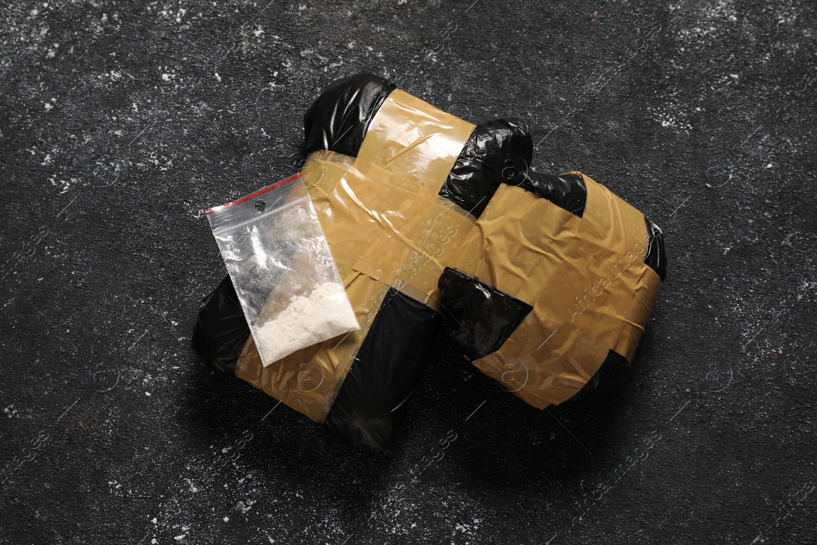 Photo of Packages with narcotics on black table, flat lay