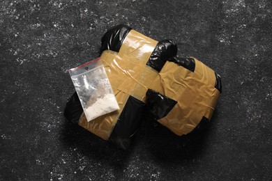 Photo of Packages with narcotics on black table, flat lay