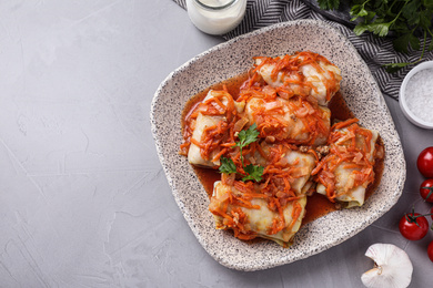 Photo of Delicious cabbage rolls served on grey table, flat lay