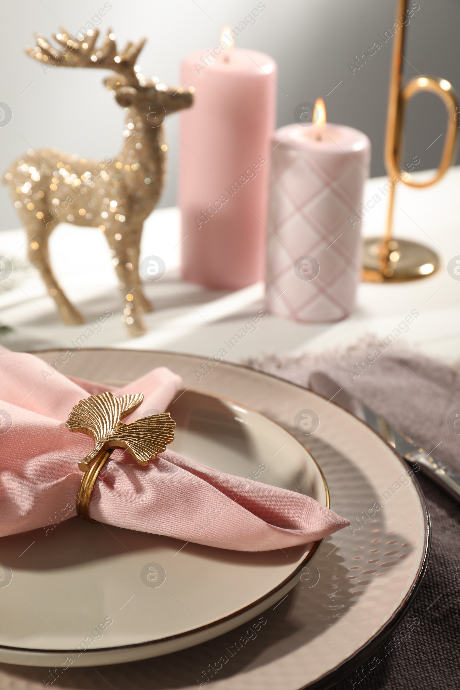 Photo of Stylish table setting with pink fabric napkin, beautiful decorative ring and festive decor on white background, closeup