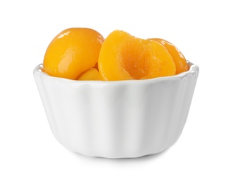 Photo of Bowl with halves of canned peaches on white background