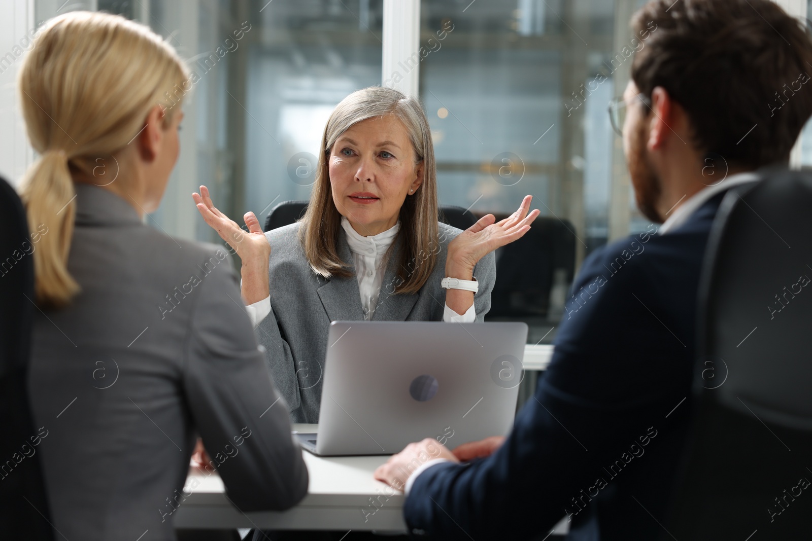 Photo of Lawyer working with clients at table in office