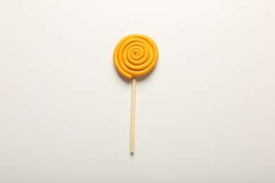 Photo of Yellow lollipop made of plasticine on white background, top view