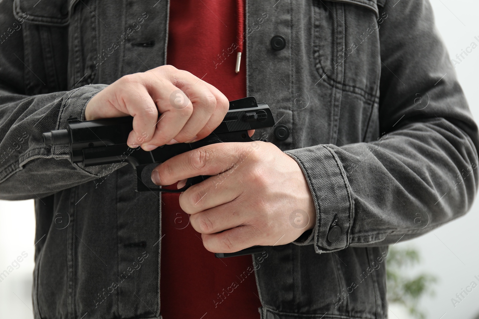 Photo of Dangerous criminal with gun in foreign house, closeup. Armed robbery