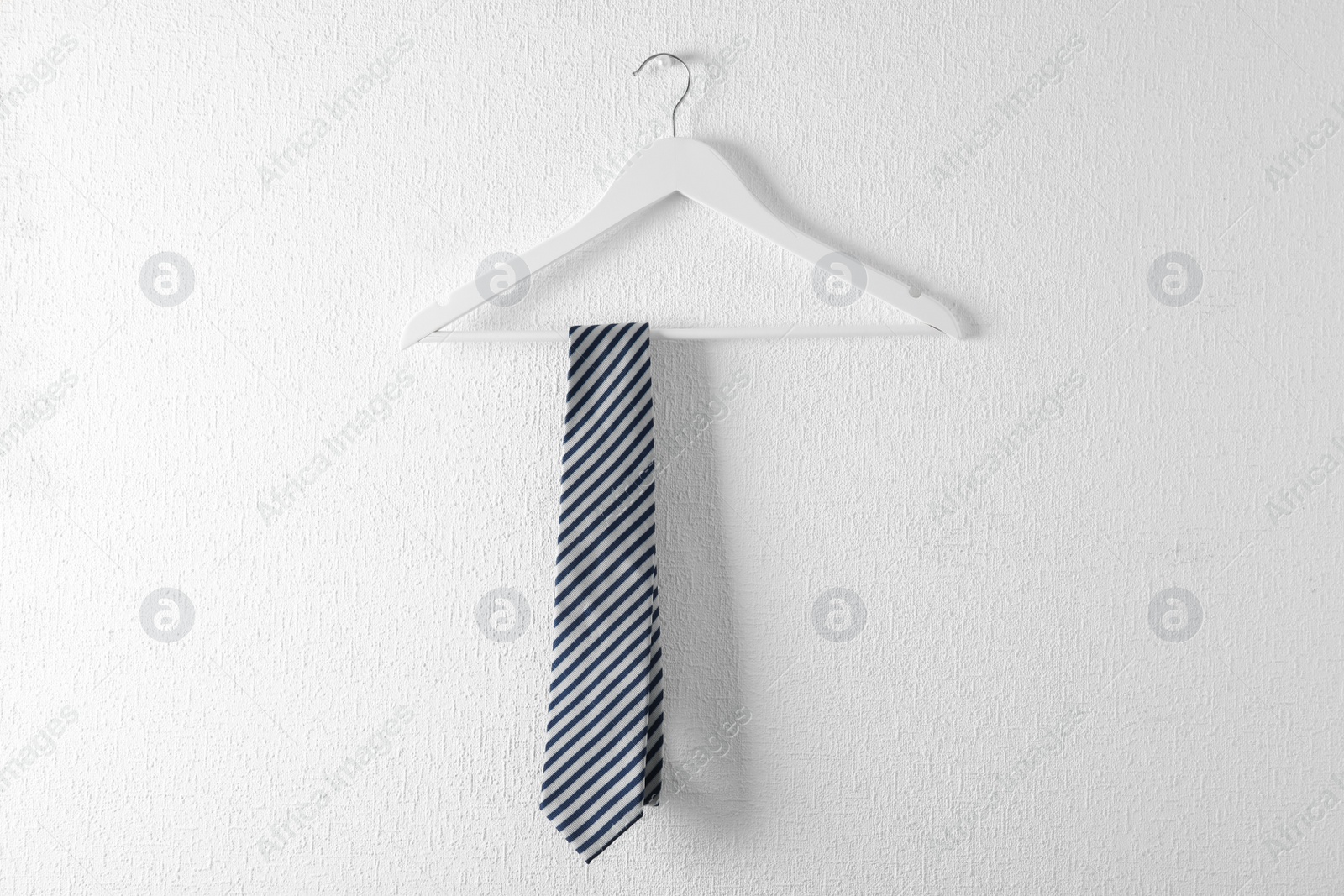 Photo of Tie on wooden hanger against white background