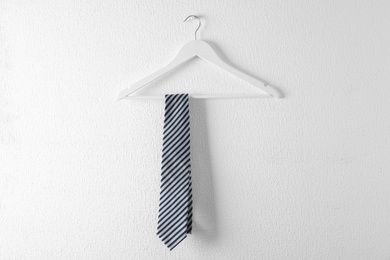 Photo of Tie on wooden hanger against white background