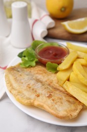 Delicious fish and chips with ketchup and lettuce on light table, closeup