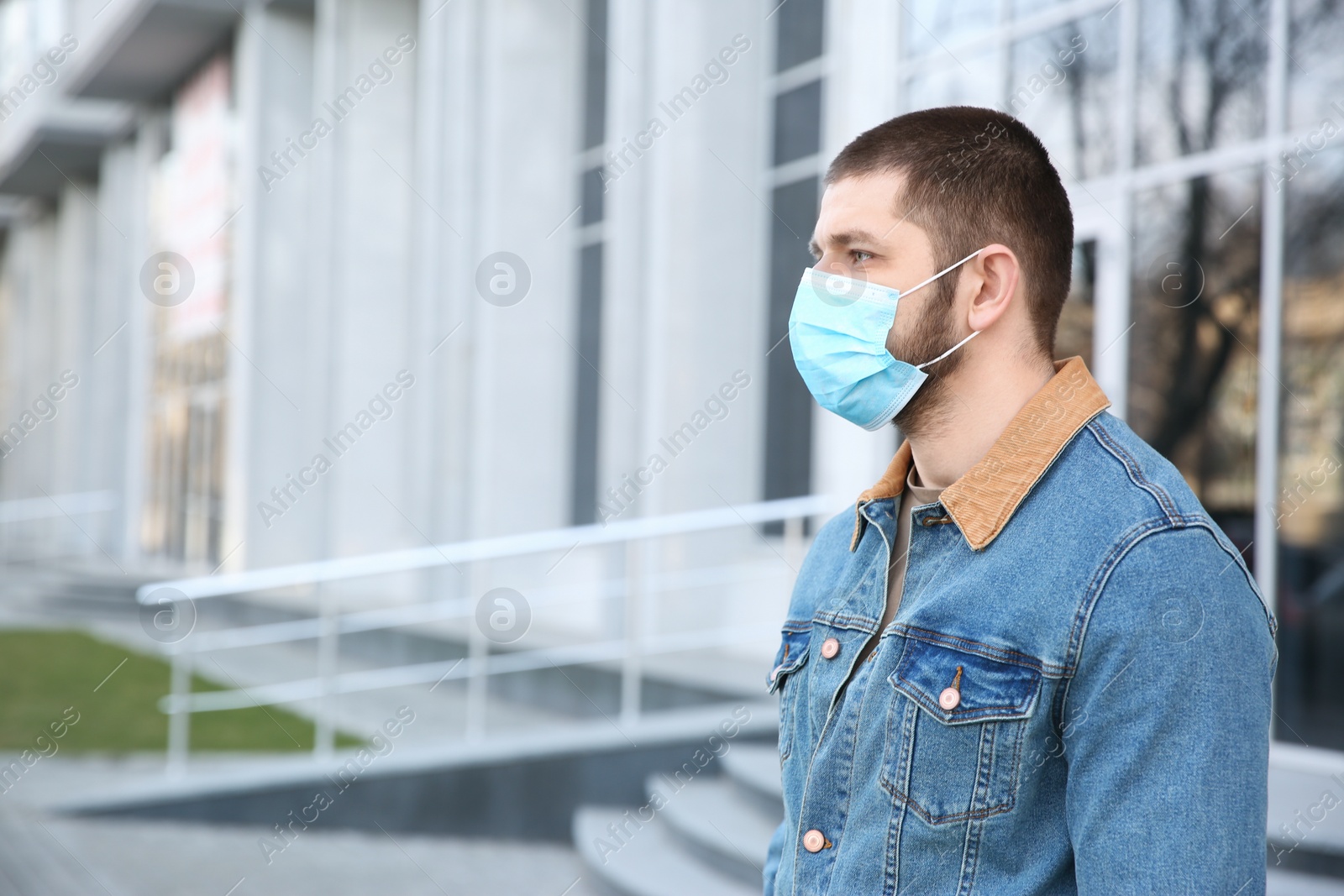 Photo of Man wearing disposable mask outdoors. Dangerous virus