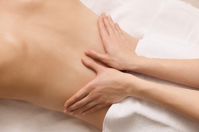 Woman receiving back massage on couch in spa salon, top view