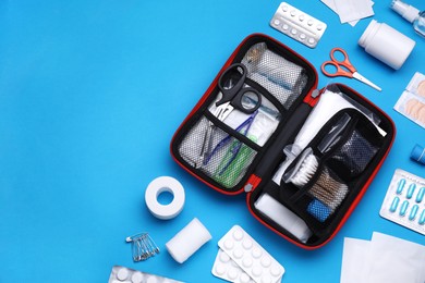 Photo of Flat lay composition with first aid kit on light blue background. Space for text