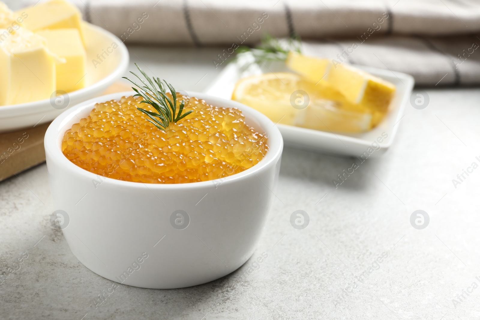 Photo of Fresh pike caviar and dill in bowl on light grey table, closeup