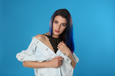 Photo of Young woman with bright dyed hair on blue background