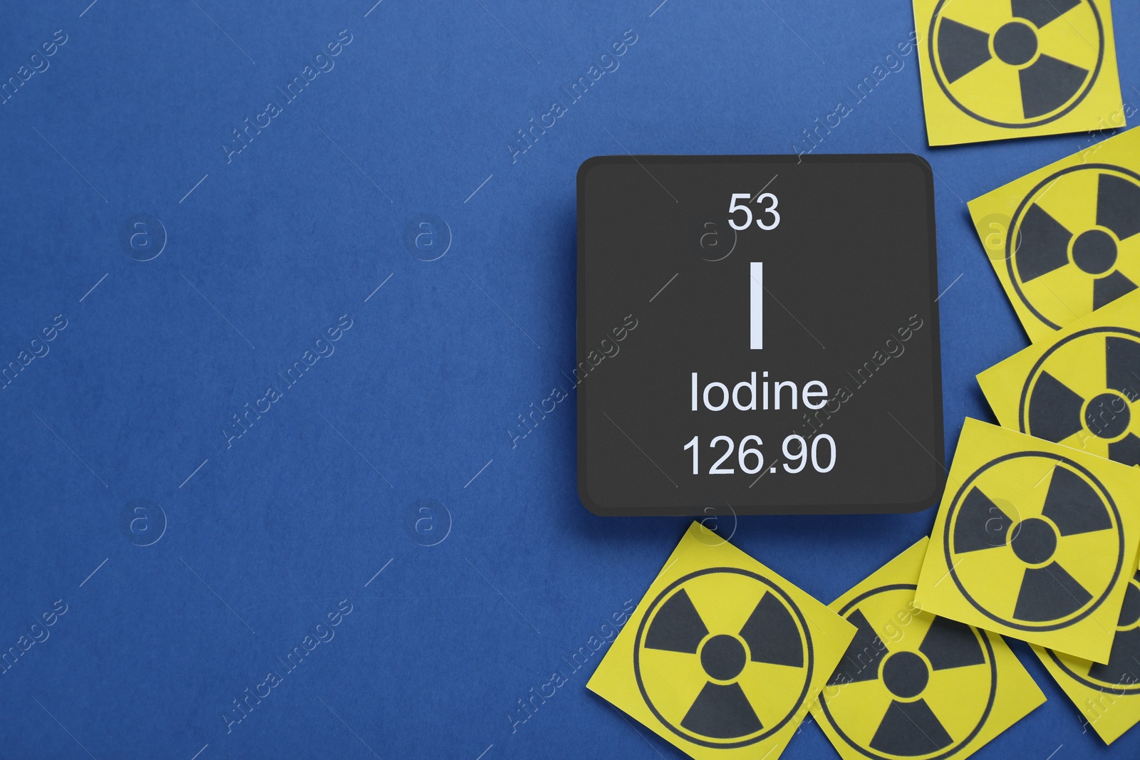 Photo of Card with chemical element Iodine and radiation signs on blue background, flat lay. Space for text
