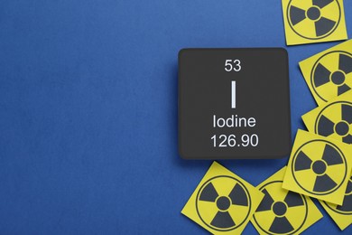 Card with chemical element Iodine and radiation signs on blue background, flat lay. Space for text