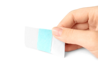 Photo of Woman putting sticking plaster on white background. First aid item