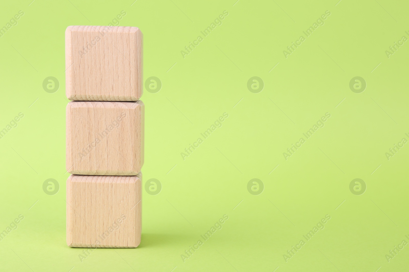 Photo of International Organization for Standardization. Wooden cubes with abbreviation ISO on light green background, closeup. Space for text