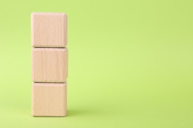 Photo of International Organization for Standardization. Wooden cubes with abbreviation ISO on light green background, closeup. Space for text