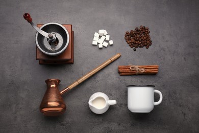 Photo of Flat lay composition with vintage manual grinder and turkish coffee pot on black table