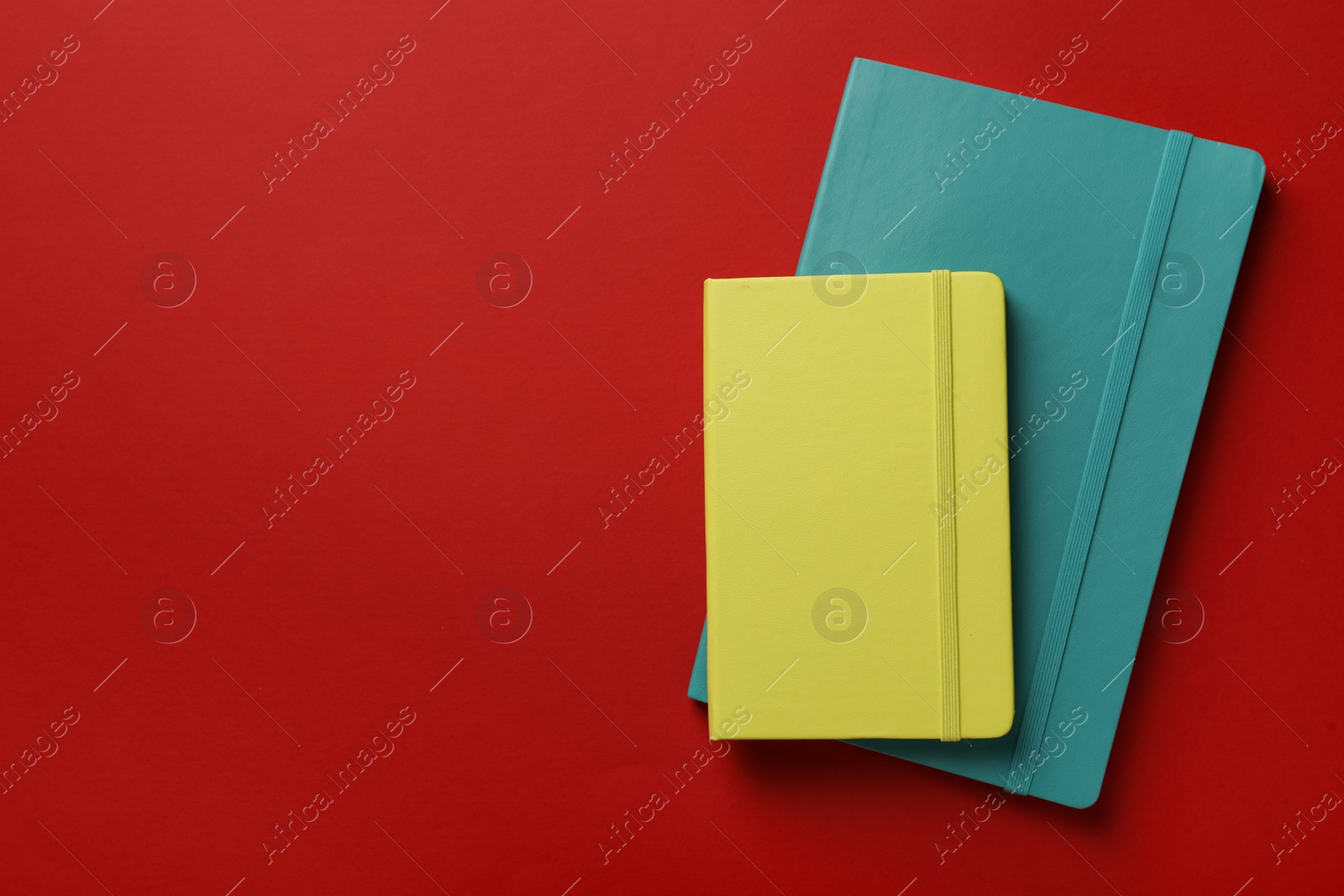 Photo of New stylish planners on red background, top view. Space for text