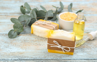 Photo of Natural handmade soap bars and ingredients on wooden table