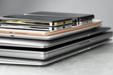 Stack of electronic devices on grey stone table, closeup