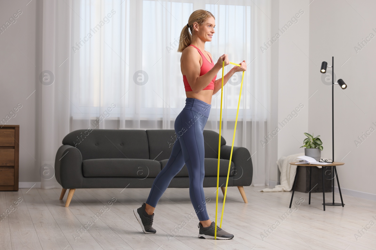 Photo of Fit woman doing exercise with fitness elastic band at home