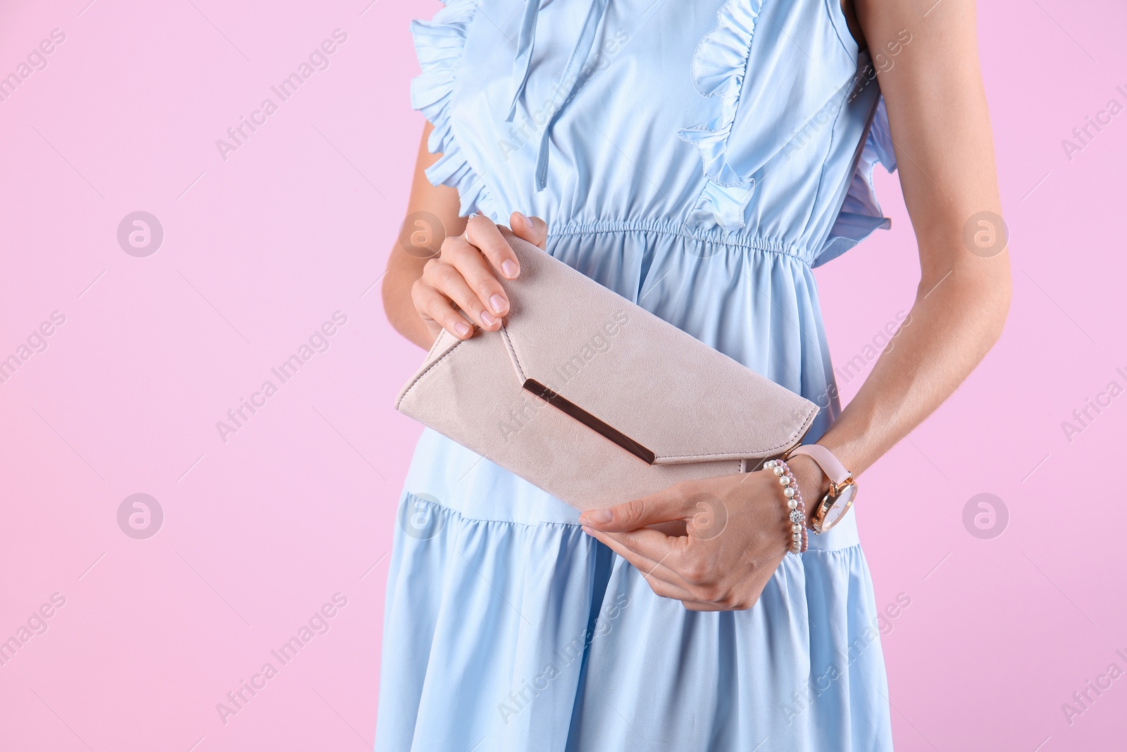 Photo of Young woman in stylish outfit with purse on color background, closeup