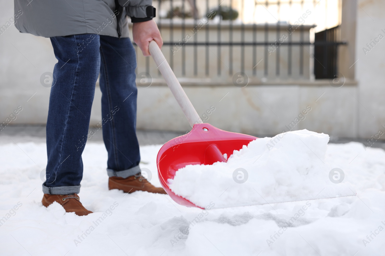 Photo of Man removing snow with shovel outdoors, closeup