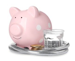 Photo of Water scarcity concept. Piggy bank, shower hose, coins and glass of drink on white background
