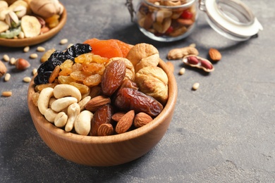 Dried fruits and nuts in dishware on table. Space for text