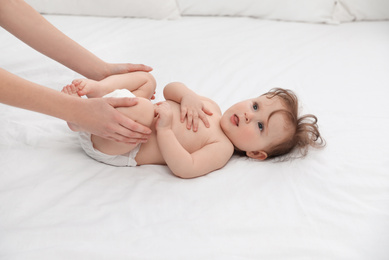 Photo of Orthopedist and cute baby on white bed