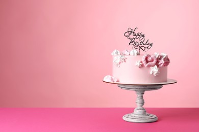 Beautifully decorated birthday cake on pink background, space for text