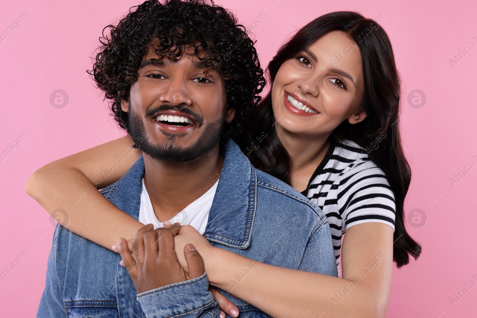 Photo of International dating. Happy couple hugging on pink background