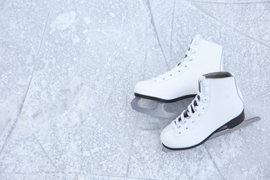Photo of Pair of figure skates on ice, top view with space for text. Winter outdoors activities