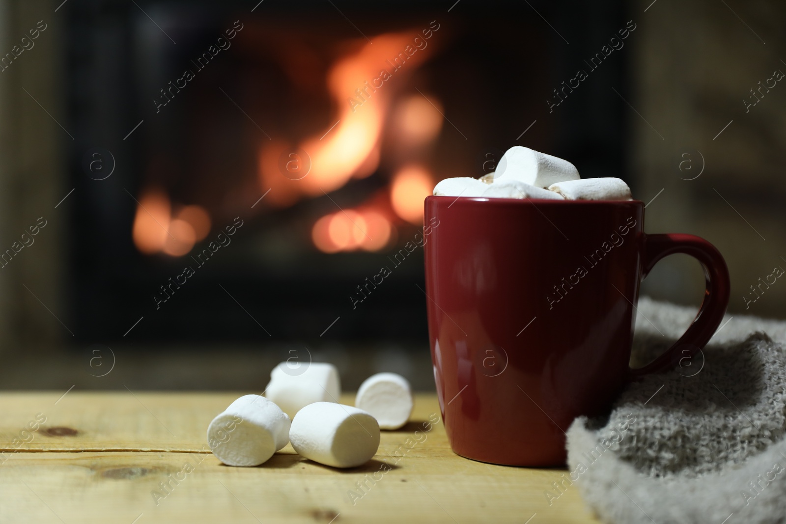 Photo of Tasty drink with marshmallows in cup on wooden table, closeup. Space for text