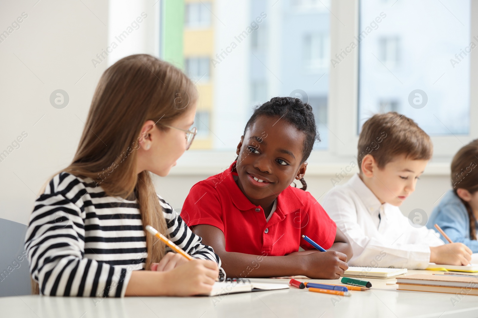 Photo of Cute children studying in classroom at school