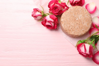 Photo of Solid shampoo bar and roses on pink wooden table, flat lay. Space for text
