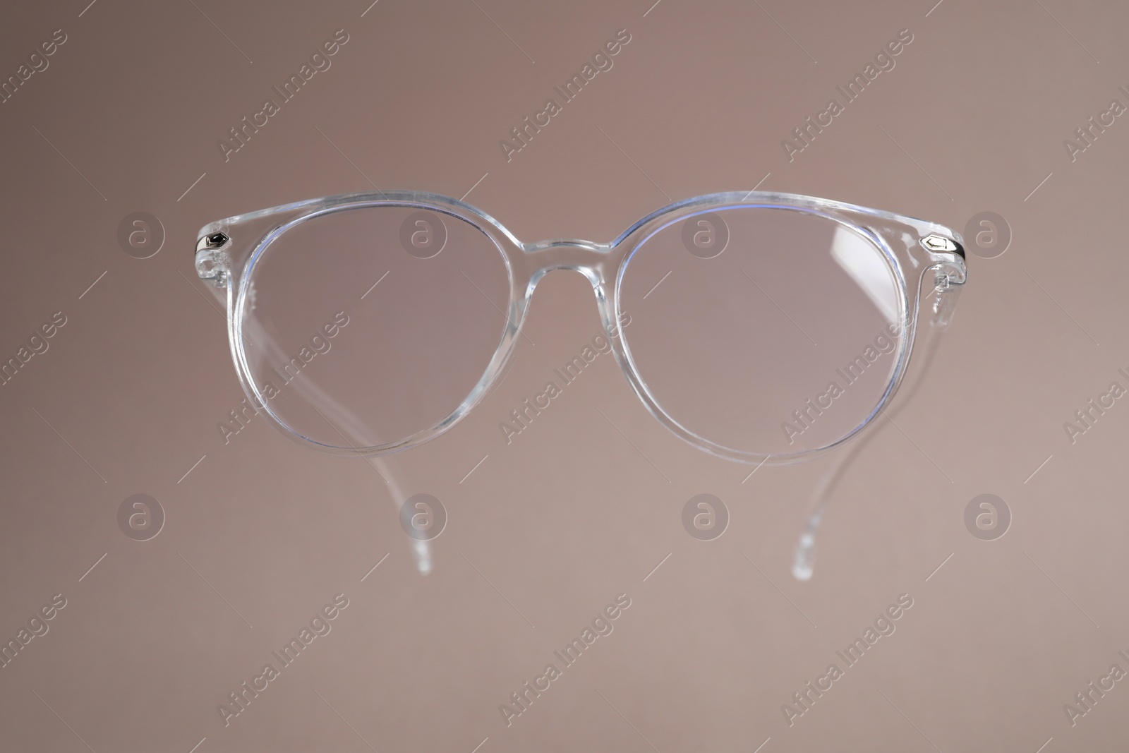 Photo of Stylish pair of glasses on pale brown background