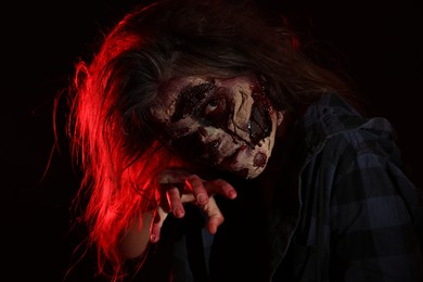 Photo of Scary zombie on dark background. Halloween monster