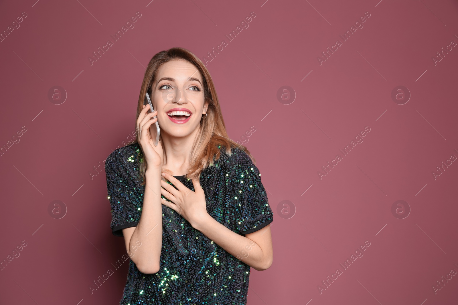 Photo of Young woman talking on phone against color background