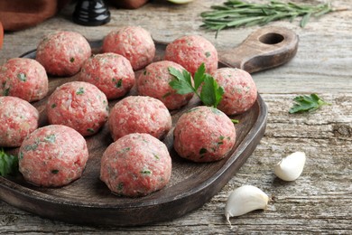 Photo of Many fresh raw meatballs on wooden table