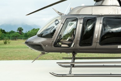 Beautiful modern helicopter on helipad in field