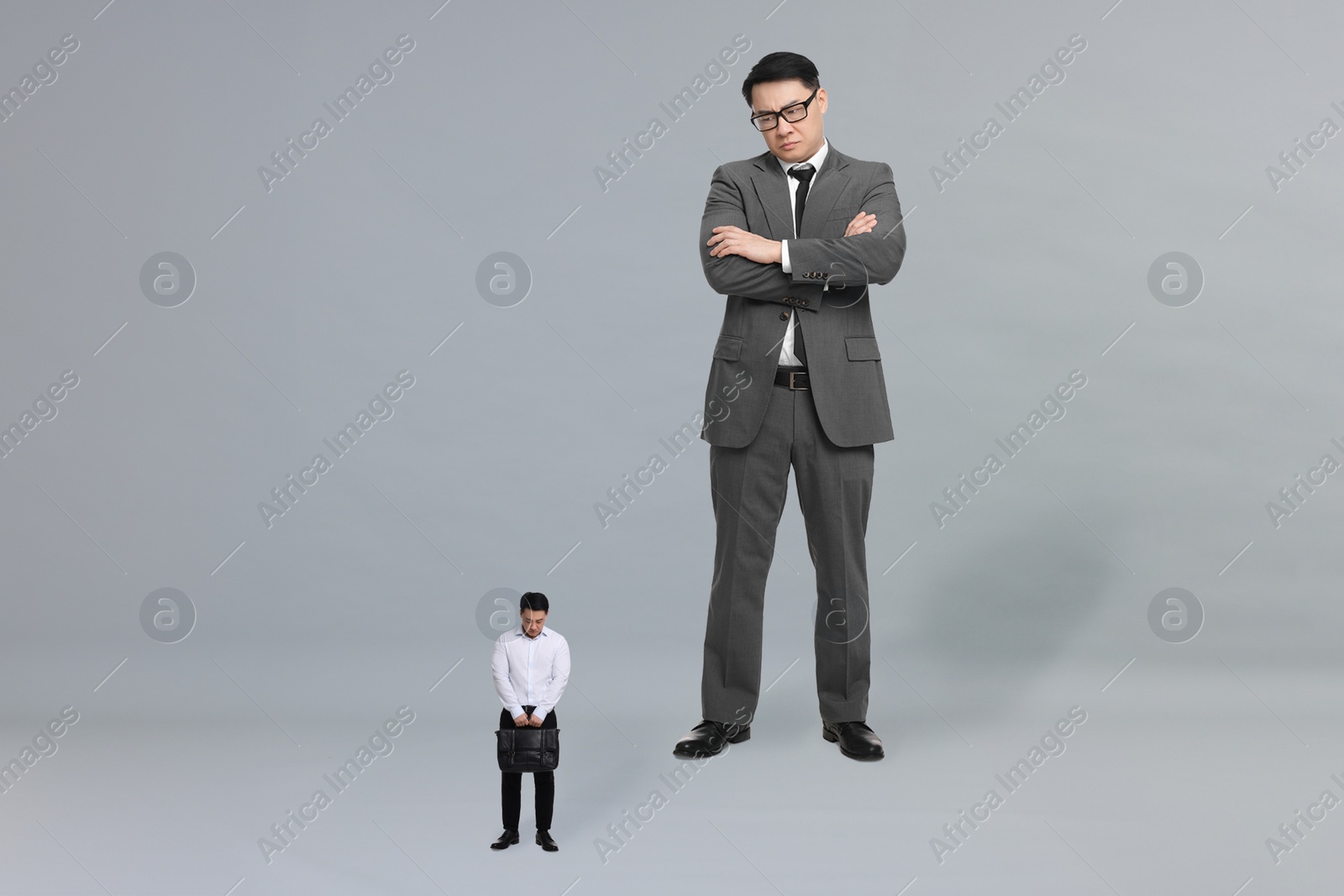 Image of Giant boss and sad small man on grey background
