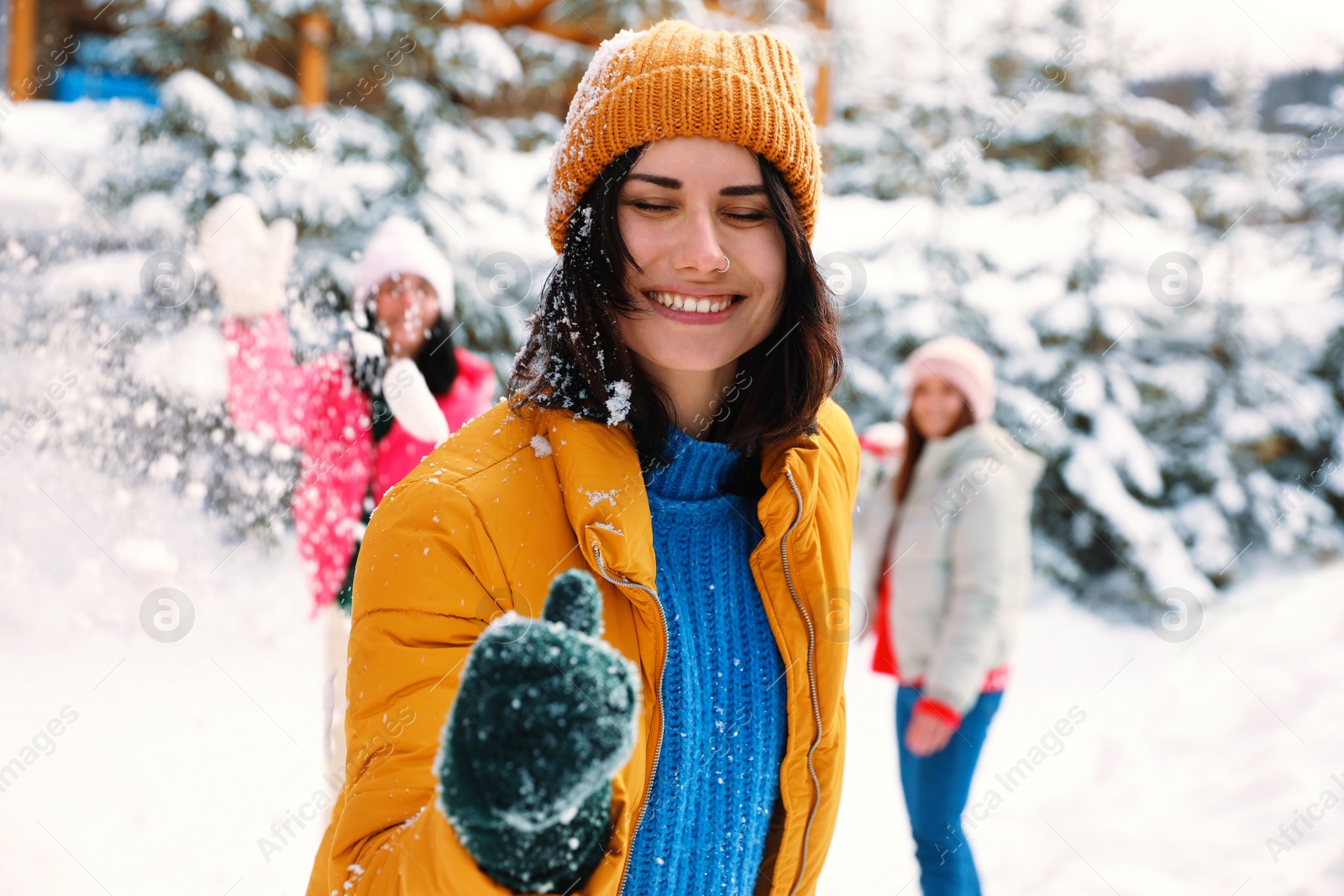 Photo of Group of friends playing snowballs outdoors. Winter vacation