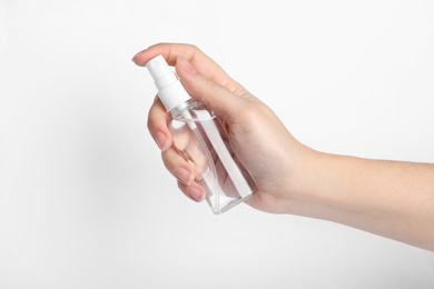 Photo of Woman holding antiseptic spray on white background, closeup