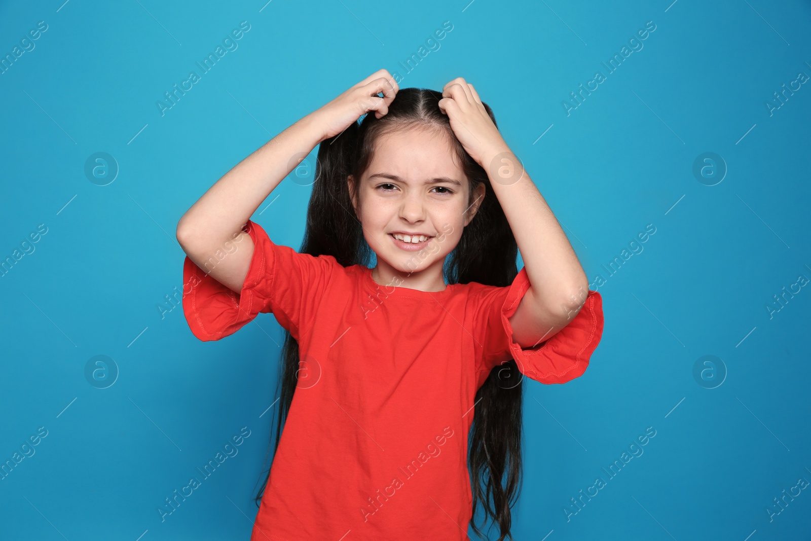 Photo of Little girl scratching head on color background. Annoying itch