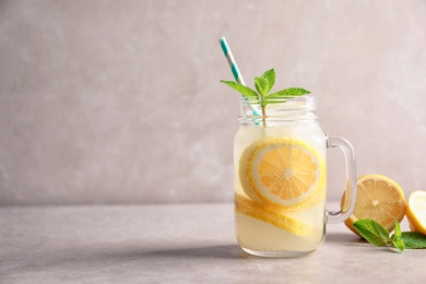 Photo of Refreshing natural lemonade in mason jar on table