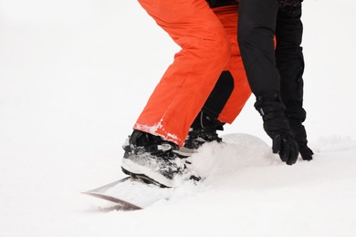 Snowboarder on slope at resort, closeup. Winter vacation