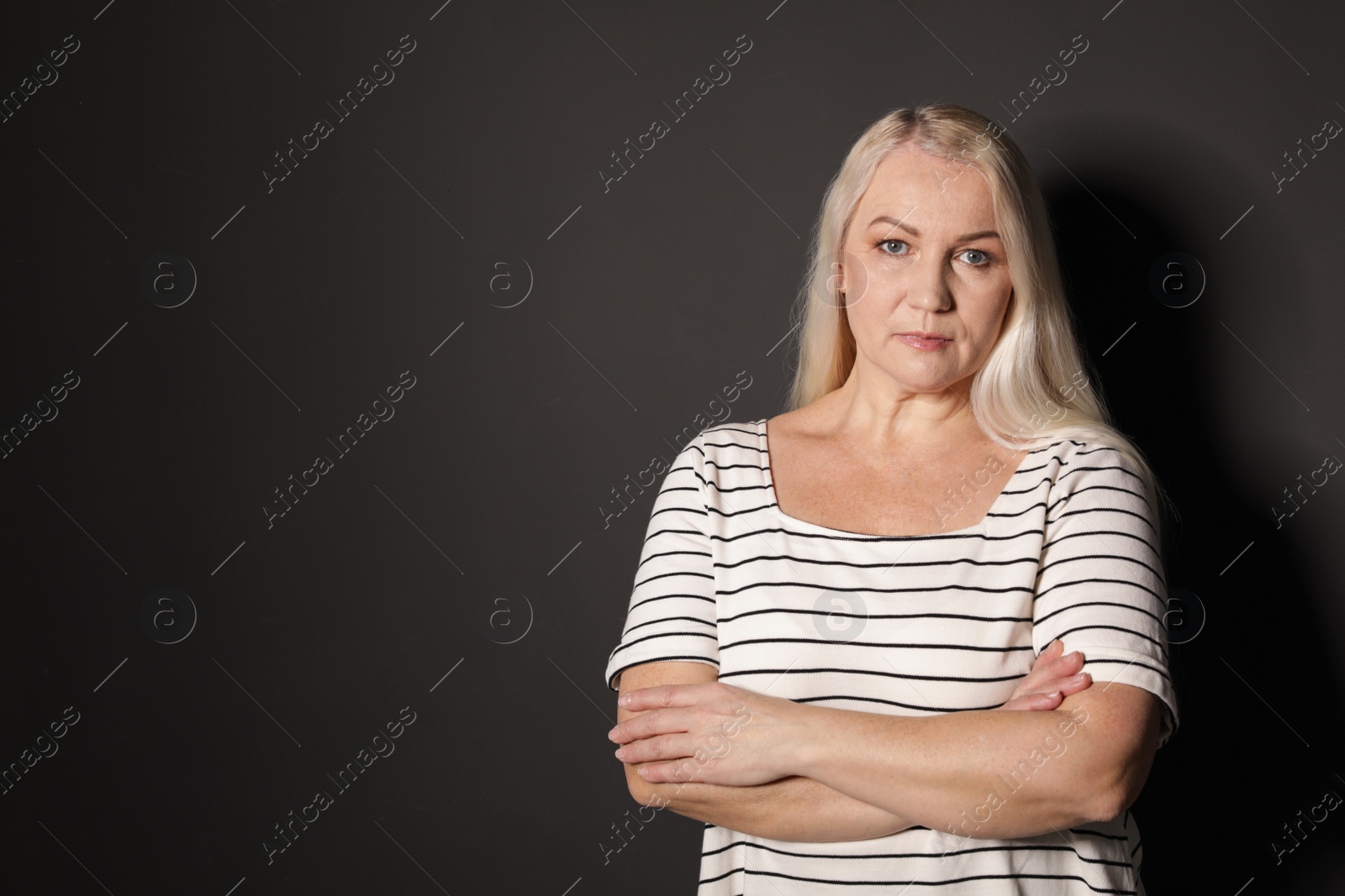 Photo of Portrait of mature woman on black background. Space for text